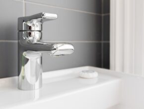 Ein silberner Wasserhahn am Waschbecken